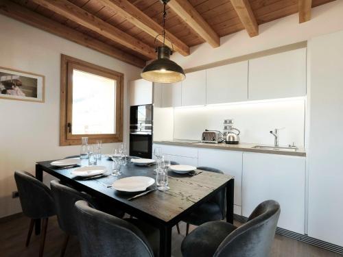 une table de salle à manger avec des chaises et une cuisine dans l'établissement Chalet Pomme de Pin · Direct sur la piste · Wifi gratuit · Sauna · Parking couvert · Proche télécabine - FR-1-344-759, à Saint-Martin-de-Belleville