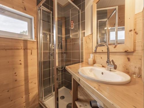 uma casa de banho com um lavatório e um chuveiro em Appartement cosy au pied des pistes em La Clusaz