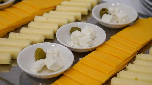 a bunch of cheese on a table with bowls of butter at Erhardt Panzió in Sopron