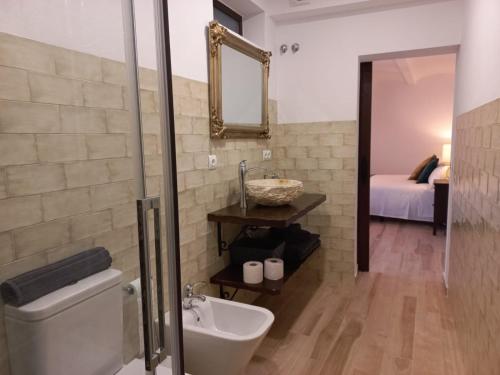 bagno con servizi igienici, lavandino e specchio di CASA RURAL ÁGUILAS HOME zhr a Zahara de la Sierra