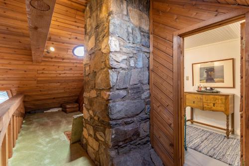ein Zimmer mit einer Steinmauer in einem Holzhaus in der Unterkunft Beech Haven in Beech Mountain