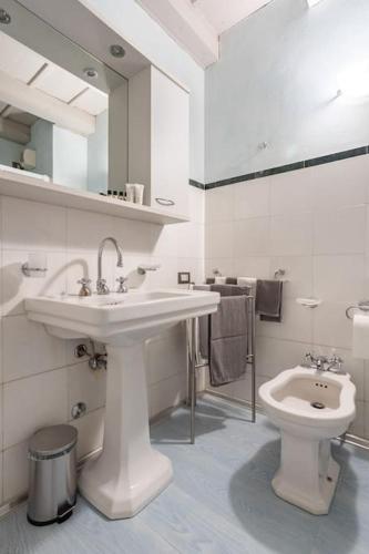 a white bathroom with a sink and a toilet at Residence dei Frutti pieno centro - Il Melograno in Padova