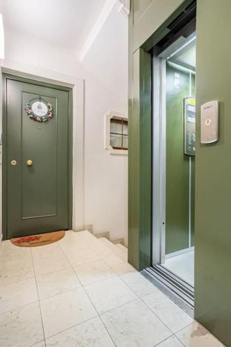 a hallway with a green door and a tile floor at Residence dei Frutti pieno centro - Il Melograno in Padova