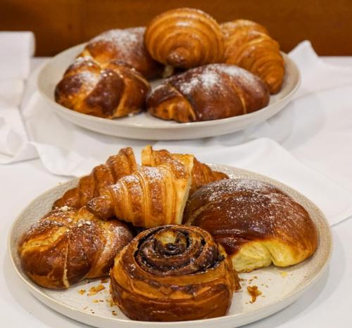 two plates of pastries and croissants on a table at Erhardt Superior Rooms in Sopron