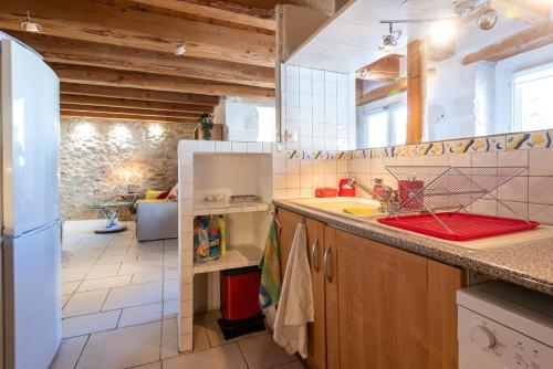 une cuisine avec un évier et un réfrigérateur dans l'établissement Le Pandora, proche Tour Magne, parking et terrasse, à Nîmes