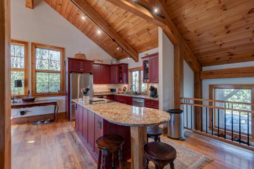 a kitchen with red cabinets and a island in a cabin at Muir Lodge in Blowing Rock