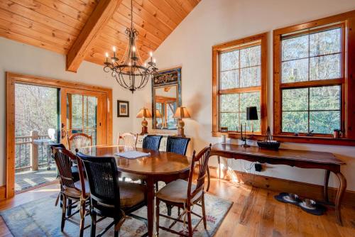 a dining room with a wooden table and chairs at Muir Lodge in Blowing Rock