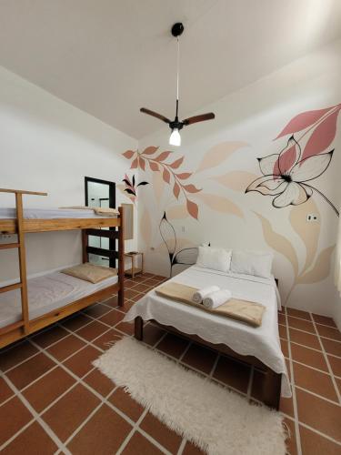 1 dormitorio con 1 cama y un mural de flores en la pared en Aldeia Ubatuba, en Ubatuba