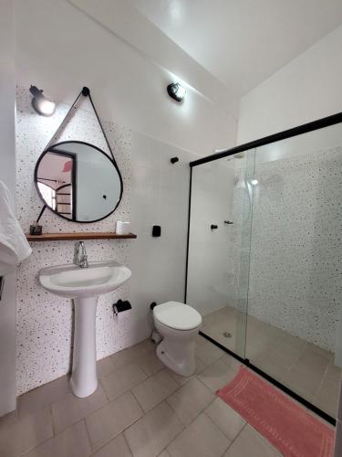a bathroom with a sink and a toilet and a mirror at Aldeia Ubatuba in Ubatuba