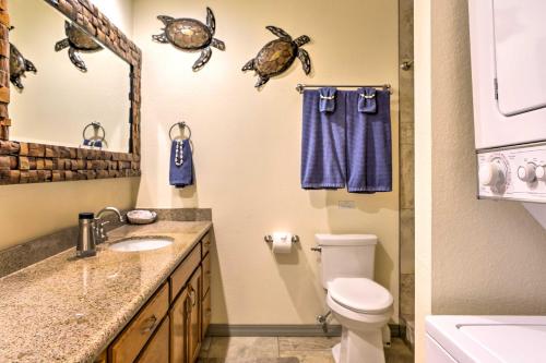 a bathroom with a toilet and a sink and a mirror at Pristine Lihue Condo with Balcony Walk to Beach! in Lihue