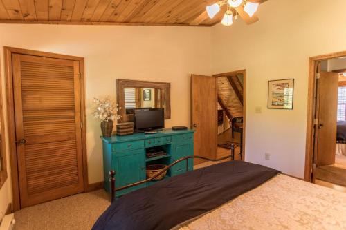 a bedroom with a bed with a blue dresser and a television at Almost Heaven in Sugar Grove
