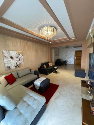 a living room with a couch and a chandelier at Big luxury apartment near airport in Nouaceur