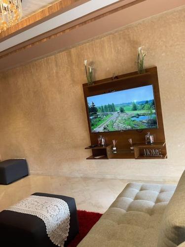 a living room with a flat screen tv on a wall at Big luxury apartment near airport in Nouaceur
