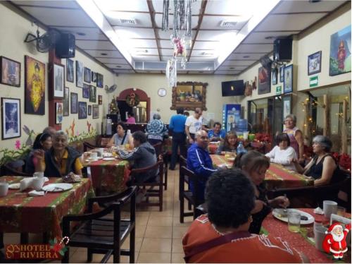 un grupo de personas sentadas en mesas en un restaurante en Hotel Riviera, en Ciudad Valles