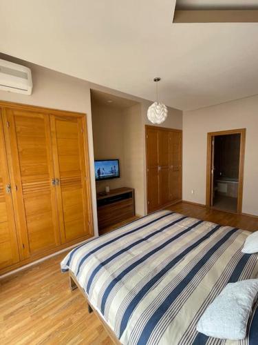 a bedroom with a large bed and a tv at Big luxury apartment near airport in Nouaceur