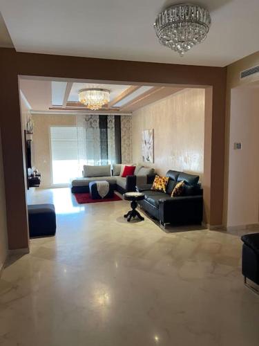 a large living room with couches and a chandelier at Big luxury apartment near airport in Nouaceur