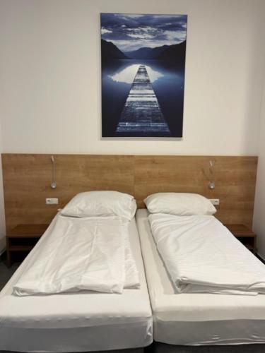 two beds in a room with a picture on the wall at Wels Inn City Apartments in Wels