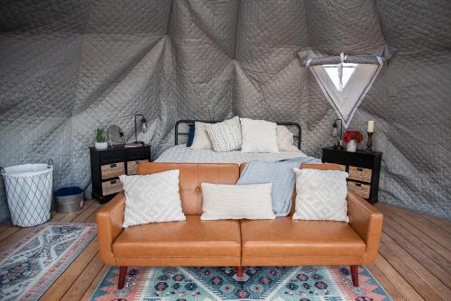 a couch in a tent with a bed in it at Little Village Retreat in New Harmony