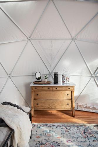 a room with a wooden dresser in a tent at Little Village Retreat in New Harmony
