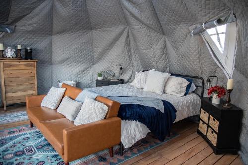 a bedroom with a tent with a bed and a couch at Little Village Retreat in New Harmony