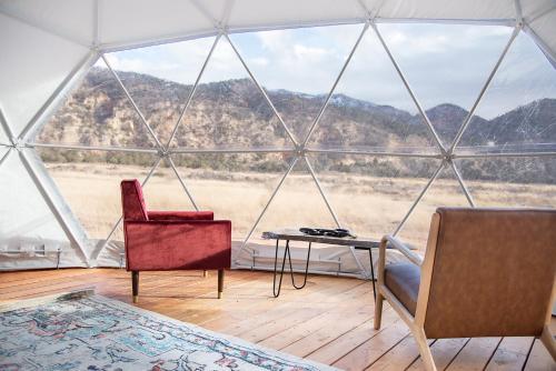 a room with two chairs and a table in a tent at Little Village Retreat in New Harmony