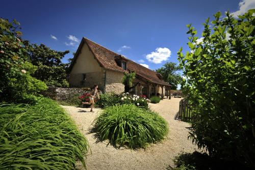 a woman walking down a path in front of a building at Manoir de Malagorse in Cuzance