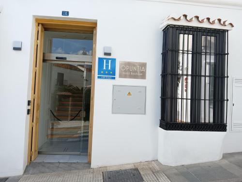 a door to a building with a sign on it at OPUNTIA Hotel Boutique in Mijas