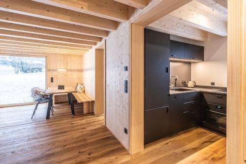 a kitchen with wooden floors and a dining room with a table at Haus im WALDner in Mellau
