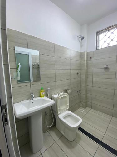 een badkamer met een toilet, een wastafel en een douche bij The Chillspot in Mombasa