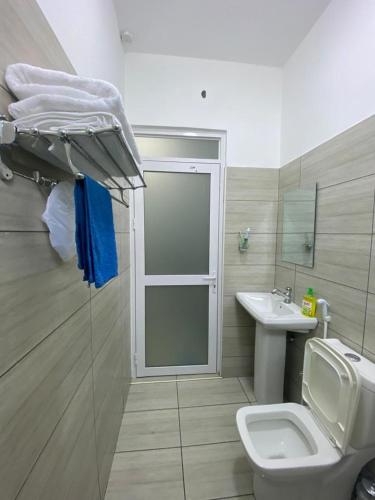 een badkamer met een douche, een toilet en een wastafel bij The Chillspot in Mombasa