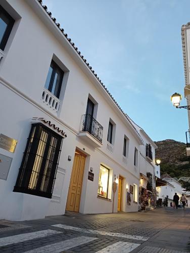 a white building with yellow doors on a street at OPUNTIA Hotel Boutique in Mijas