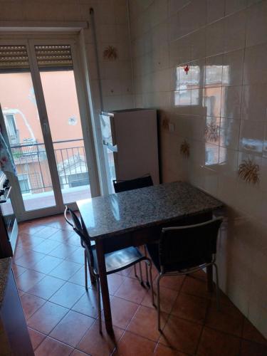 a kitchen with a table and chairs and a refrigerator at Casa Roncaccia in Grottaferrata