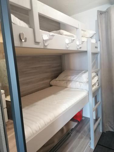 Cette chambre dispose de lits superposés blancs. dans l'établissement Appartement studio domaine de l'Alpe d'Huez, Villard Reculas, à Villard-Reculas