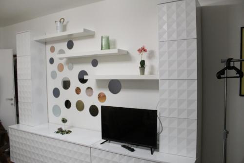 a living room with a tv on a white wall at N&AA apartman in Belgrade