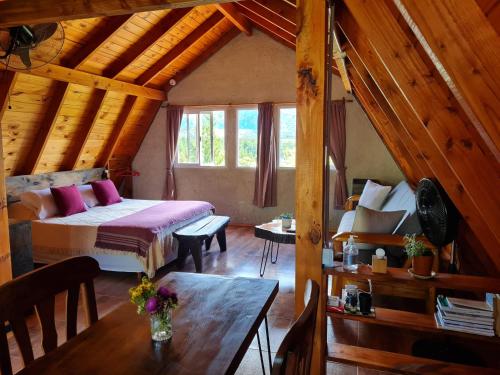 1 dormitorio con 1 cama y 1 mesa en una habitación en La Amarilla Casa de Huéspedes Ruta 40 Montañas en Epuyén