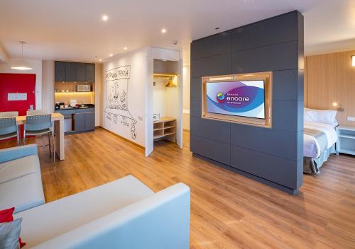 a hotel room with a bed and a tv on a wall at Ramada Encore by Wyndham Guadalajara Aeropuerto in Guadalajara