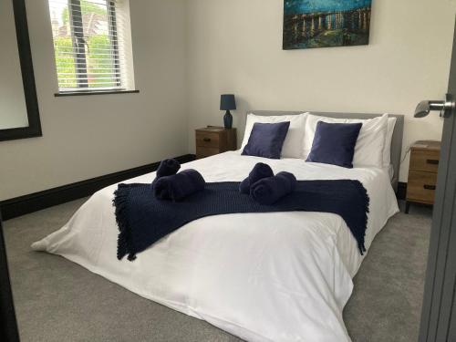 a bedroom with a large white bed with blue pillows at Little Elm - luxury home from home, free parking, 30-40 mins walk from Bath city centre in Bath