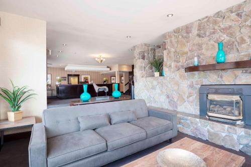 a living room with a couch and a fireplace at Sandman Hotel Cranbrook in Cranbrook
