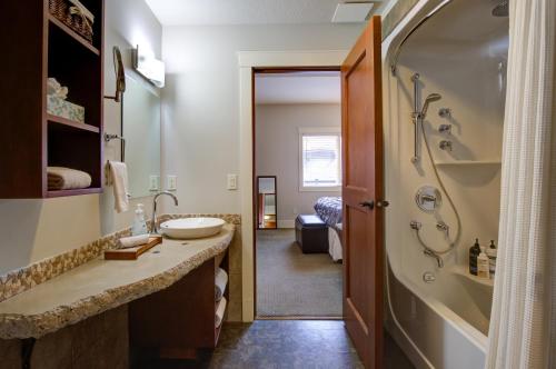 ein Badezimmer mit einer Dusche, einem Waschbecken und einer Badewanne in der Unterkunft Misty Mountain- Premium 2 Bedroom Mountain View in Canmore