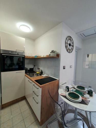 a kitchen with a table and a clock on the wall at Negotin Centar Apartment with Parking in Negotin