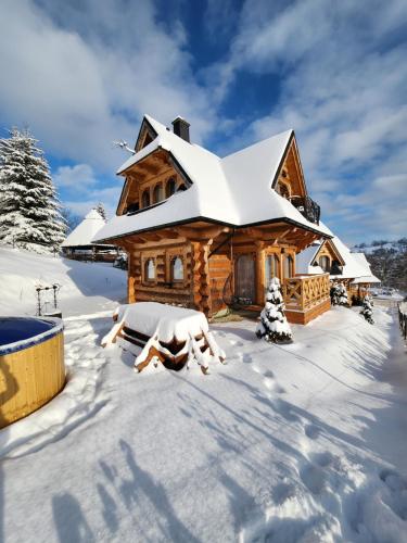 a log cabin in the snow with snow at Góralska Chatka 3 Highland Cottage - Jacuzzi, Sauna, Split AC, Private parking, Mountains View in Zakopane