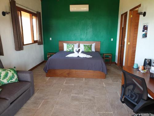 a bedroom with a bed with a green wall at Palmetto Lodge in Playa San Miguel 