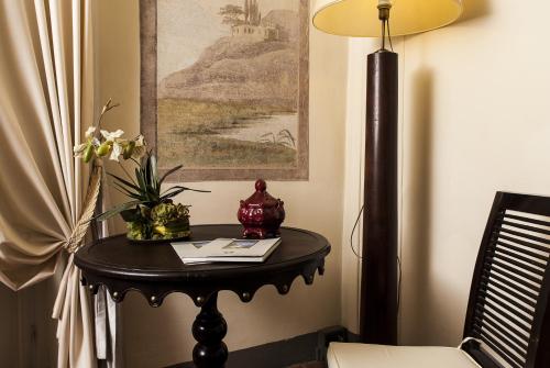 una mesa en una habitación con una foto y flores en ella en Residenza d'Epoca Palazzo Galletti en Florencia