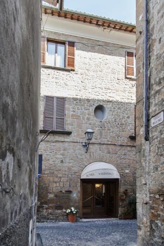 a stone building with a doorway in a street at Hotel Valentino Centro Storico in Orvieto