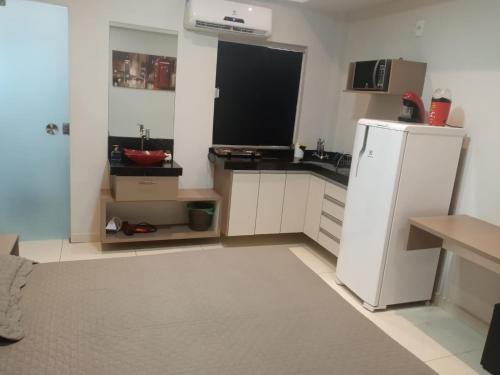 a kitchen with a white refrigerator and a sink at Studio Maraba-LOFT LINDO in Marabá