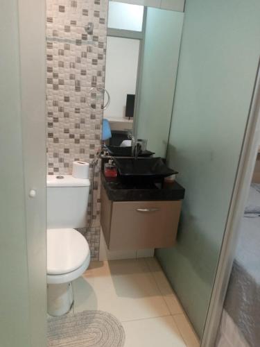 a bathroom with a toilet and a sink and a mirror at Studio Maraba-LOFT LINDO in Marabá