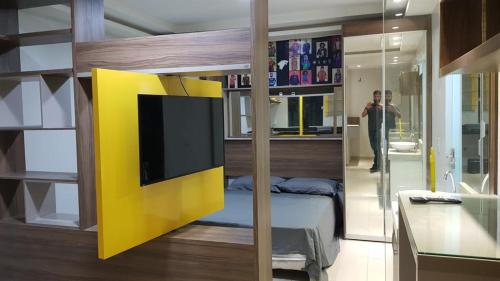 um quarto com uma cama com uma parede amarela em Studio Maraba-LOFT LINDO em Marabá