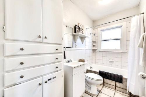 Baño blanco con aseo y lavamanos en Natural Sabbatical 1 Bedroom Apartment en Dallas