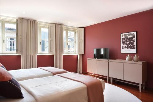 two beds in a bedroom with red walls at Nº150 Apartment Triplex with Suites and Terrace in Braga