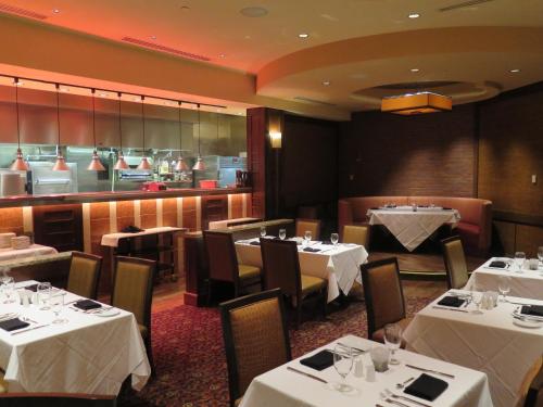 a restaurant with white tables and chairs and a kitchen at Harrah's Joliet, A Caesars Destination in Joliet